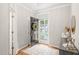 Bright foyer with hardwood floors, decorative rug, stylish console table, and a black front door adorned with a wreath at 203 Lighthouse Way, Cary, NC 27511