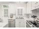 Bright kitchen features stainless steel appliances, white cabinetry, and a double basin sink at 203 Lighthouse Way, Cary, NC 27511