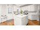 Bright kitchen featuring white cabinets, an island, stainless steel appliances, and hardwood floors for a cooking experience at 203 Lighthouse Way, Cary, NC 27511