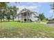 Back exterior with a screened-in porch, patio seating, fire pit, and large yard at 205 Sherman Pines Dr, Fuquay Varina, NC 27526