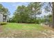 Spacious backyard featuring lush greenery and a serene pond view at 205 Sherman Pines Dr, Fuquay Varina, NC 27526