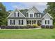 Charming two-story home featuring black shutters, gray siding, and a well-manicured front yard with lush landscaping at 205 Sherman Pines Dr, Fuquay Varina, NC 27526