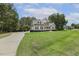 Beautiful gray home with black shutters, lush green lawn, and a long driveway leading to the side of the house at 205 Sherman Pines Dr, Fuquay Varina, NC 27526