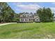Beautiful gray home with black shutters and lush green lawn and tree line at 205 Sherman Pines Dr, Fuquay Varina, NC 27526
