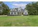 Attractive two-story home with gray siding, black shutters, and a well-maintained lawn with mature trees at 205 Sherman Pines Dr, Fuquay Varina, NC 27526