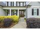 Inviting front porch with double doors, bright yellow bushes, and black shutters at 205 Sherman Pines Dr, Fuquay Varina, NC 27526