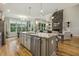 Kitchen island with bar seating overlooks the living room with fireplace at 205 Sherman Pines Dr, Fuquay Varina, NC 27526