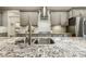 Close-up on the kitchen with granite countertops, stainless sink, tiled backsplash, and range at 205 Sherman Pines Dr, Fuquay Varina, NC 27526