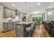 Open-concept kitchen features gray cabinets, granite countertops, stainless steel appliances, and wood flooring at 205 Sherman Pines Dr, Fuquay Varina, NC 27526