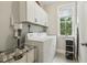Bright laundry room with window, washer, dryer, storage and white cabinets at 205 Sherman Pines Dr, Fuquay Varina, NC 27526