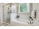 Modern main bathroom with separate tub and shower, white tile, and wood-look floors at 205 Sherman Pines Dr, Fuquay Varina, NC 27526