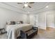 This main bedroom features a tray ceiling, a ceiling fan, and ensuite bathroom access at 205 Sherman Pines Dr, Fuquay Varina, NC 27526