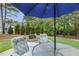 Outdoor patio featuring an umbrella table with chairs, a stone fire pit, and landscaped backyard at 205 Sherman Pines Dr, Fuquay Varina, NC 27526