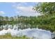 Scenic view of a pond surrounded by lush trees, reflecting the clear blue sky at 205 Sherman Pines Dr, Fuquay Varina, NC 27526