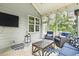 Relax in this screened porch with a ceiling fan, TV, and comfortable seating on a decorative rug at 205 Sherman Pines Dr, Fuquay Varina, NC 27526