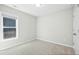 Neutral bedroom featuring a single window and a closet door, creating a peaceful space at 21 Diploma Dr, Clayton, NC 27520