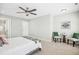 Light-filled bedroom boasts a ceiling fan, door to bathroom, and cozy seating area at 21 Diploma Dr, Clayton, NC 27520