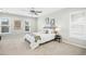 Well-lit bedroom with neutral tones, featuring a plush bed, ceiling fan, and dual windows at 21 Diploma Dr, Clayton, NC 27520