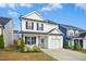 Charming two-story home features a light blue front door, garage, and manicured lawn at 21 Diploma Dr, Clayton, NC 27520