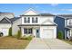 Charming two-story home features a light blue front door, garage, and manicured lawn at 21 Diploma Dr, Clayton, NC 27520