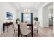 Bright dining room features a modern chandelier, white wainscoting, and wood floors at 222 Trailing Oak Trl, Clayton, NC 27527
