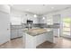 Well-lit kitchen with white cabinets, granite countertops, stainless appliances, and an eat-in island at 222 Trailing Oak Trl, Clayton, NC 27527