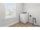 Bright laundry room with vinyl floor, washer, and window view at 222 Trailing Oak Trl, Clayton, NC 27527
