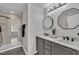 Bathroom featuring a double vanity and tiled walk-in shower, offering both style and function at 231 Grindstone Dr, Apex, NC 27502