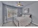 Cozy bedroom featuring a metal bed frame, ceiling fan, and ample natural light from a window at 231 Grindstone Dr, Apex, NC 27502