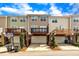 Townhome exterior with balconies, garages, and well-maintained landscaping, creating an inviting curb appeal at 231 Grindstone Dr, Apex, NC 27502