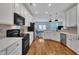 Open kitchen featuring hardwood floors and stainless appliances at 231 Grindstone Dr, Apex, NC 27502