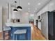 Open kitchen with white cabinets, stainless steel appliances, breakfast bar, and wood floors at 231 Grindstone Dr, Apex, NC 27502