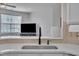 Close up of sink and faucet looking into living room with TV and natural light at 231 Grindstone Dr, Apex, NC 27502