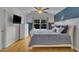 Bright bedroom features a ceiling fan, TV, and hardwood floors creating a relaxing ambiance at 231 Grindstone Dr, Apex, NC 27502