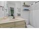 Bright bathroom featuring a white vanity with framed mirror, and open shelving at 2410 Overbrook Ln, Sanford, NC 27330