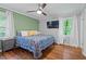 Well-lit bedroom with hardwood floors, ceiling fan, and view of the trees outside the window at 2410 Overbrook Ln, Sanford, NC 27330