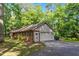 A brick home with an attached garage and well-maintained landscaping in a natural wooded setting at 2410 Overbrook Ln, Sanford, NC 27330