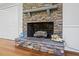Stone fireplace with mantel, wooden logs, and decorative accents add charm to this living space at 2410 Overbrook Ln, Sanford, NC 27330