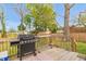 Outdoor cooking area with a grill on a wooden deck surrounded by a fenced backyard at 2508 Albany St, Durham, NC 27705