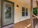 Cozy covered front porch with wood accents and a welcoming entrance and 'welcome friends' doormat at 280 Sagamore Dr, Louisburg, NC 27549