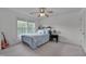 Bright bedroom with a ceiling fan, a light blue bedspread, and a large window at 3019 Britmass Dr, Raleigh, NC 27616