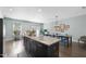Bright dining area with access to outdoor patio and modern island with dark wood cabinets at 309 Old Mill Village Dr, Apex, NC 27502