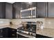 Close-up of kitchen with stainless steel oven, granite countertops, and modern backsplash at 309 Old Mill Village Dr, Apex, NC 27502
