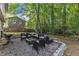 Outdoor patio with stone surround and outdoor seating with barbecue grill surrounded by trees at 309 Penn Oak Cir, Raleigh, NC 27615