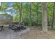 Landscaped backyard featuring a seating area with stone surround and mature trees at 309 Penn Oak Cir, Raleigh, NC 27615