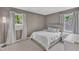 Comfortable bedroom with neutral color palette and natural light from two windows at 309 Penn Oak Cir, Raleigh, NC 27615
