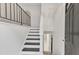 Bright, minimalist entryway featuring black-and-white stairs and a view into an adjacent room at 309 Penn Oak Cir, Raleigh, NC 27615
