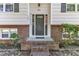 A welcoming front entrance featuring a brick porch, neutral door, and manicured landscaping at 309 Penn Oak Cir, Raleigh, NC 27615