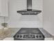 Close-up of a range with granite countertops and tile backsplash at 309 Penn Oak Cir, Raleigh, NC 27615