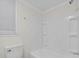 Clean bathroom featuring a white shower and tub combo with a white toilet at 313 W Church St, Angier, NC 27501